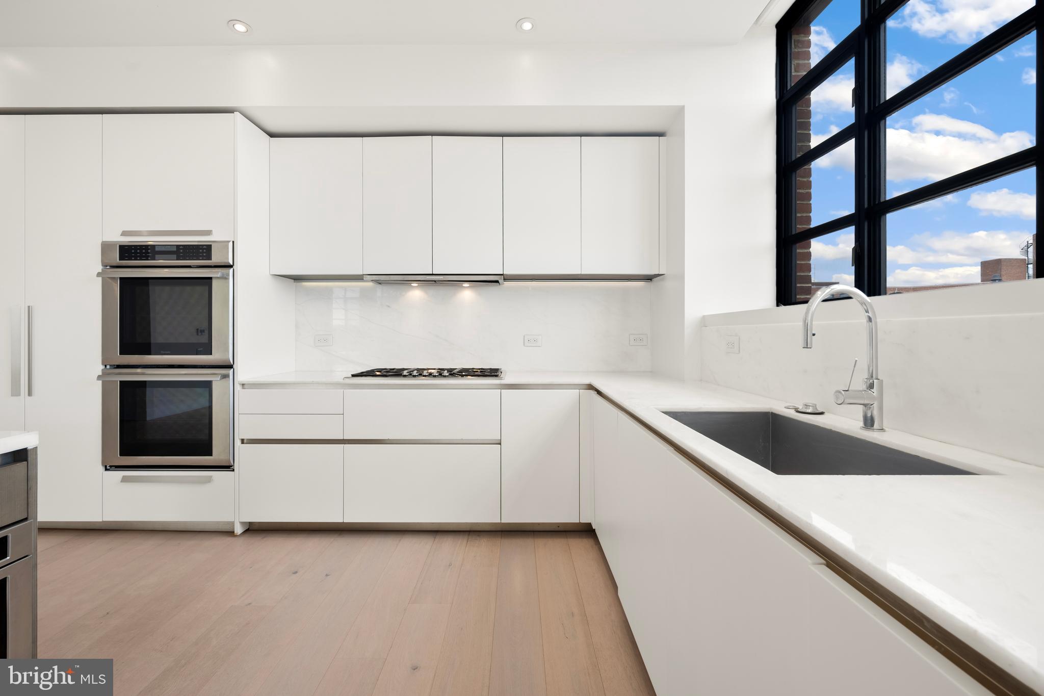 1055 Wisconsin Avenue Northwest, Unit 4E Washington, DC 20007 - Photo 9 of 58 a kitchen with a refrigerator and a sink