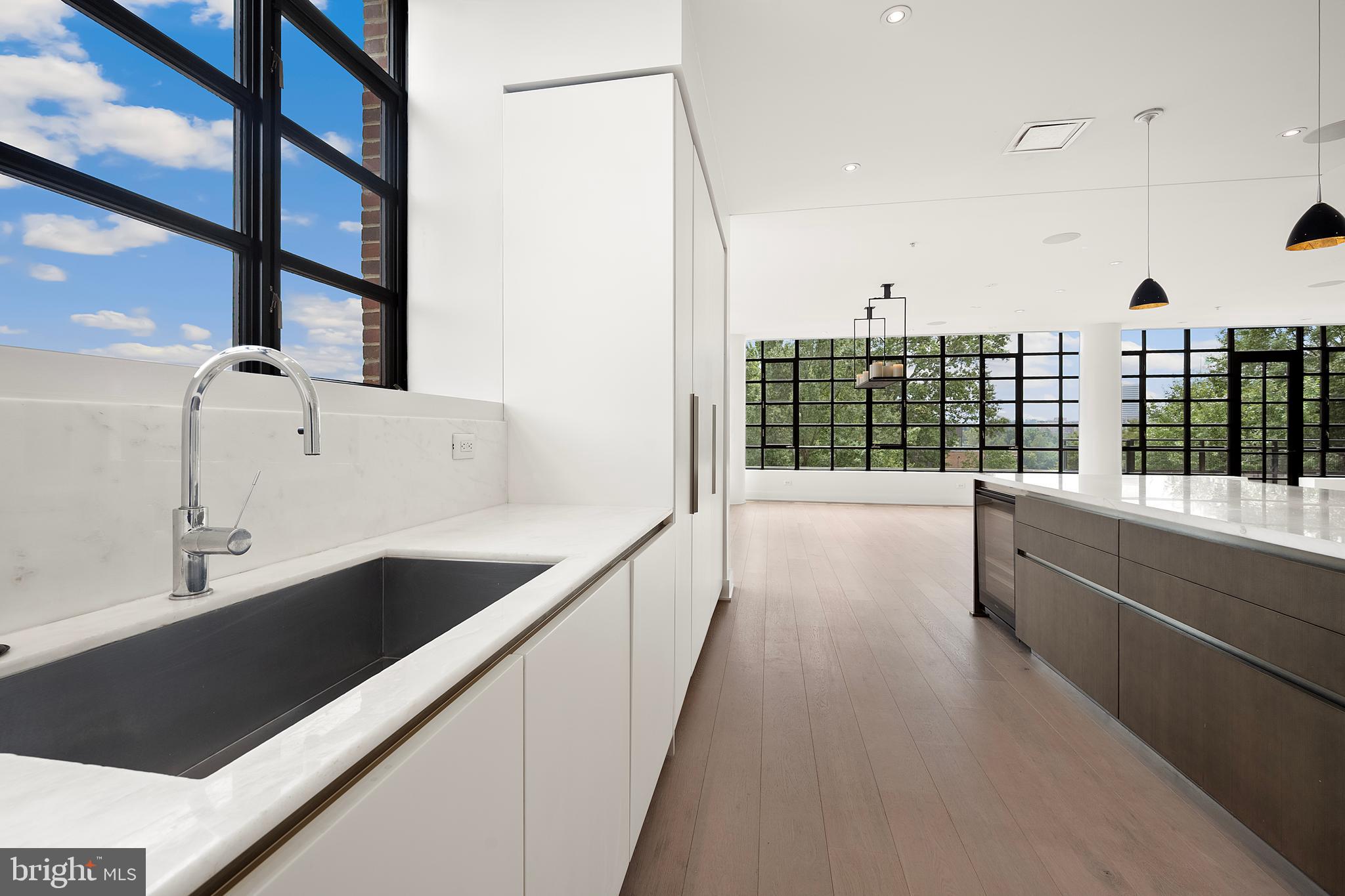 1055 Wisconsin Avenue Northwest, Unit 4E Washington, DC 20007 - Photo 10 of 58 a view of a kitchen with kitchen island a large window a sink and a counter top space