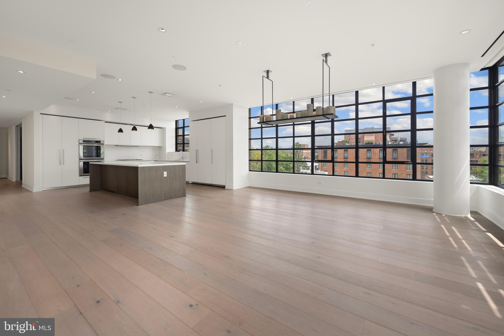 1055 Wisconsin Avenue Northwest, Unit 4E Washington, DC 20007 - Photo 12 of 58 a view of a kitchen with stainless steel appliances wooden floor and large windows