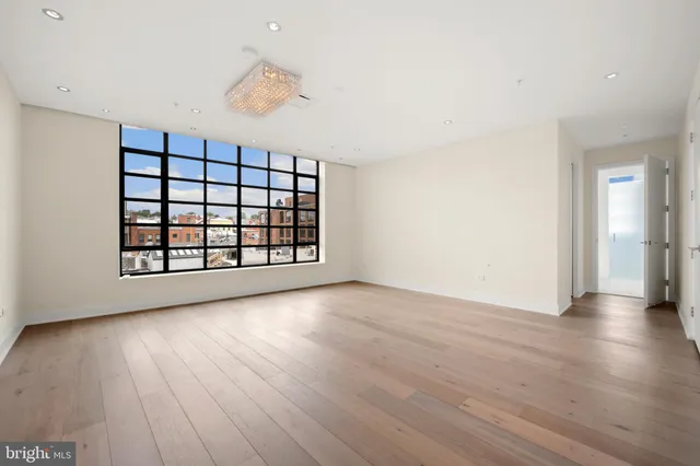 a spacious bedroom with a large bed a couch and a potted plant