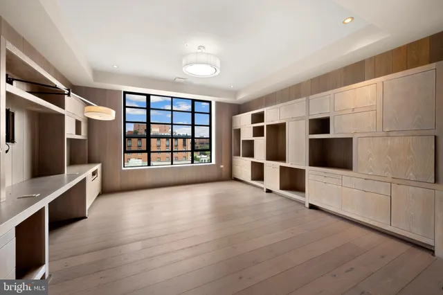 a view of an empty room with a window and cabinet