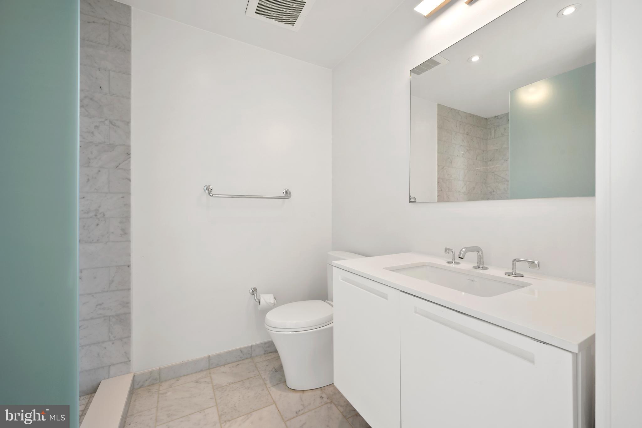 1055 Wisconsin Avenue Northwest, Unit 4E Washington, DC 20007 - Photo 34 of 58 a bathroom with a toilet sink and mirror