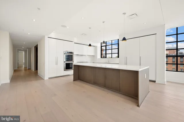 a kitchen with stainless steel appliances kitchen island granite countertop a refrigerator and a sink