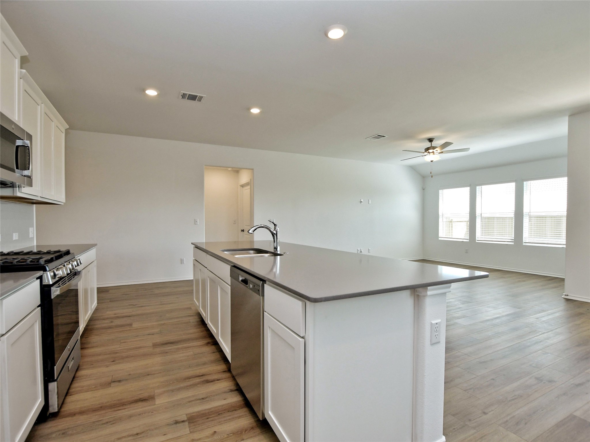 229 Vortex Pass Kyle, TX 78640 - Photo 13 of 32 a kitchen with granite countertop a sink and stove top oven