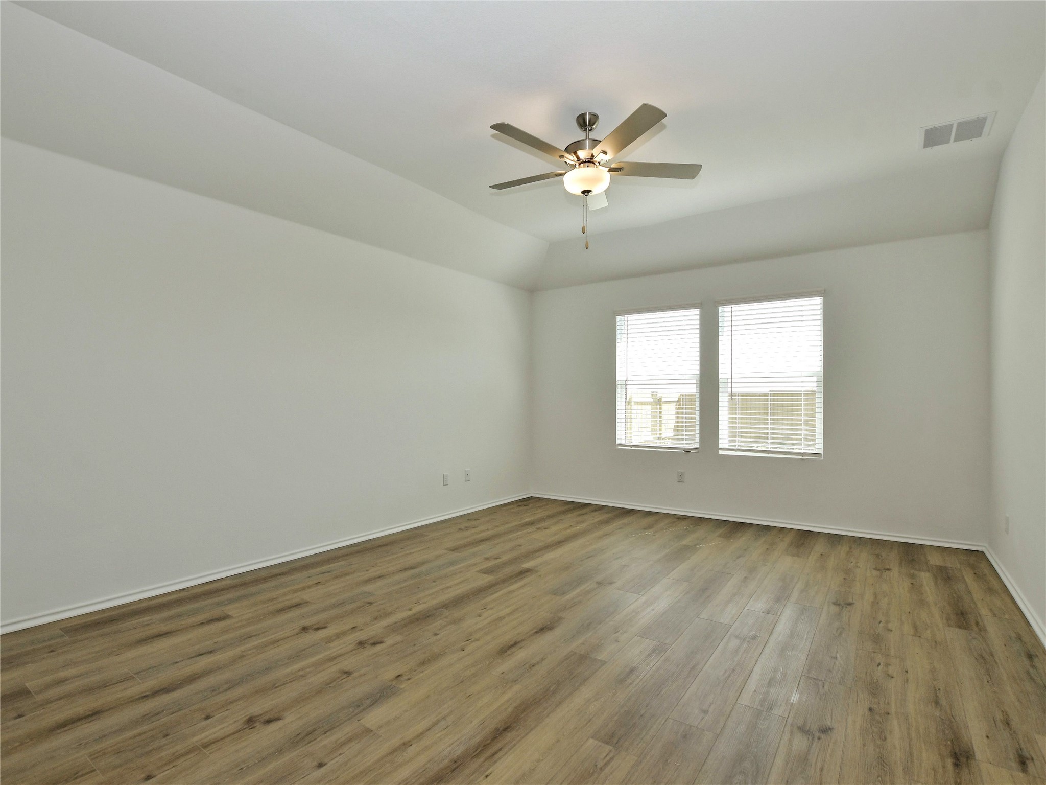 229 Vortex Pass Kyle, TX 78640 - Photo 17 of 32 a view of an empty room with wooden floor and a window