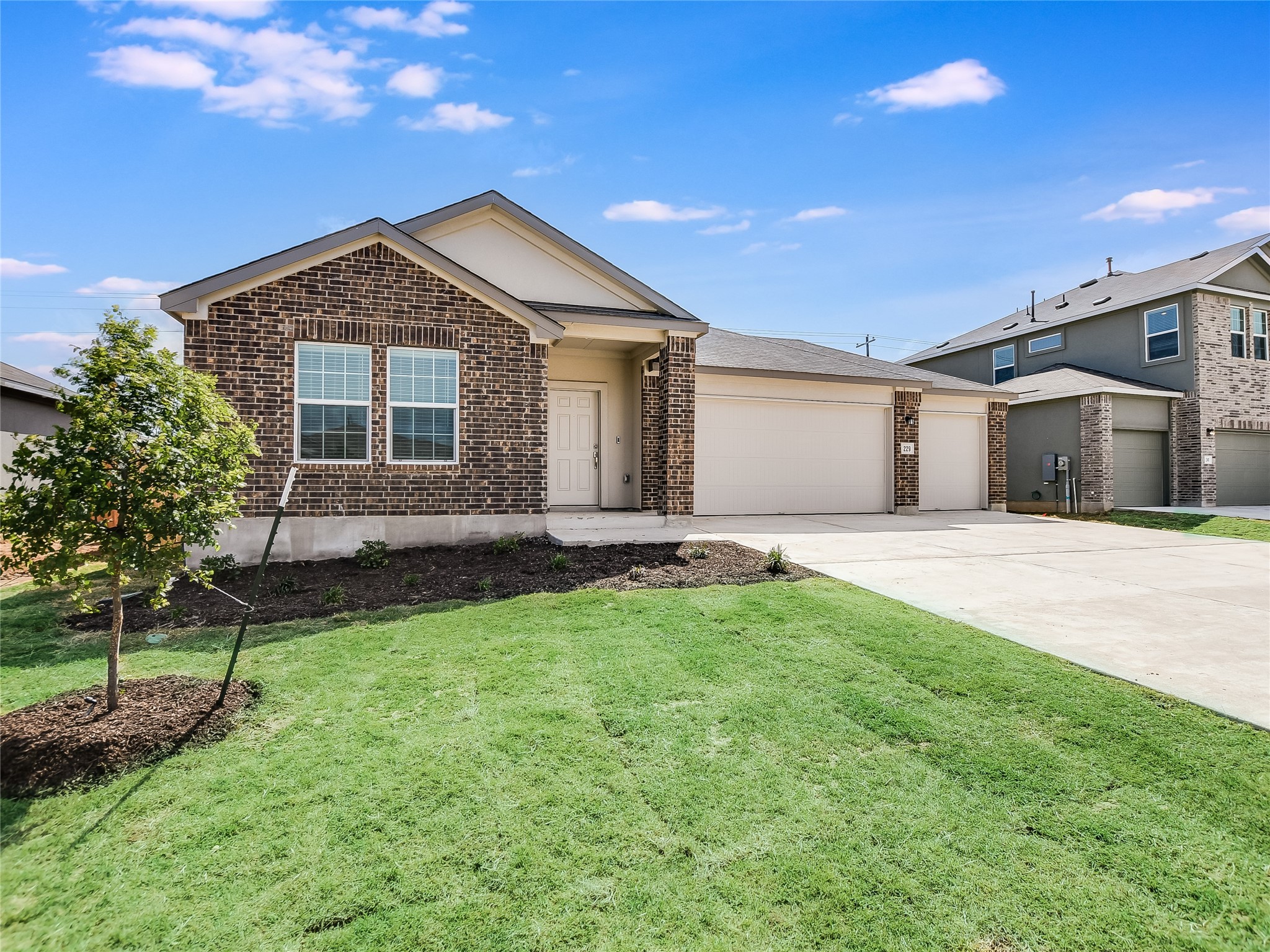 229 Vortex Pass Kyle, TX 78640 - Photo 2 of 32 a front view of a house with a yard and garage