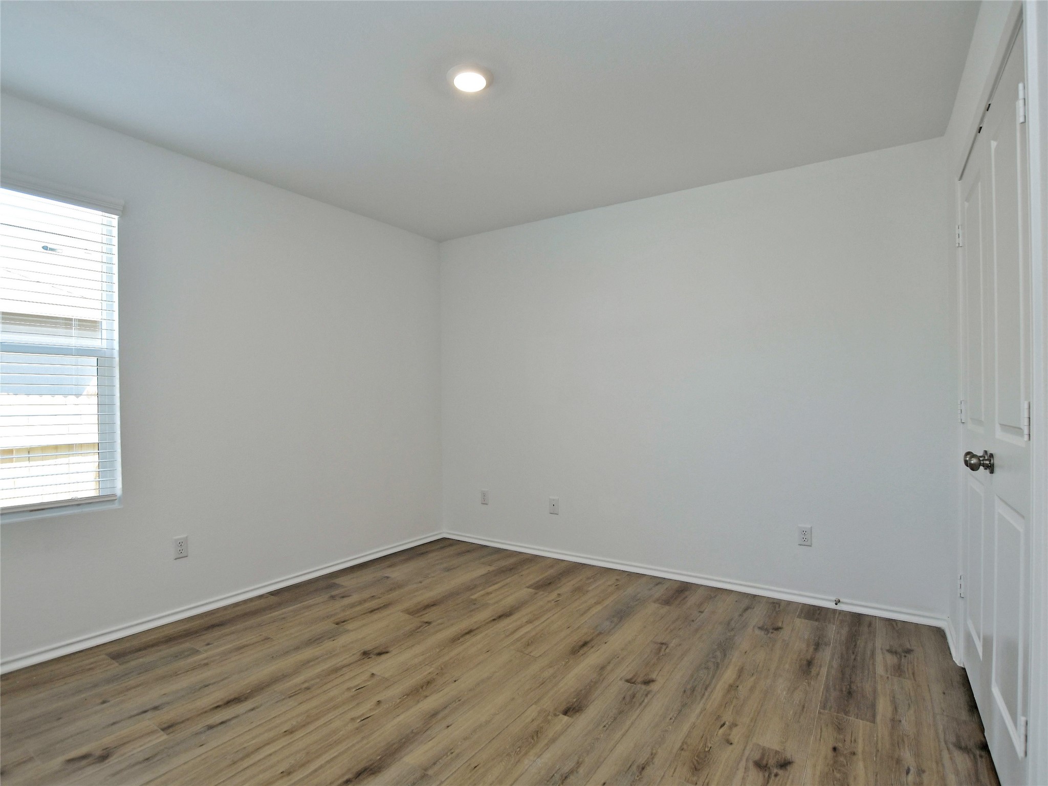 229 Vortex Pass Kyle, TX 78640 - Photo 23 of 32 an empty room with wooden floor and windows