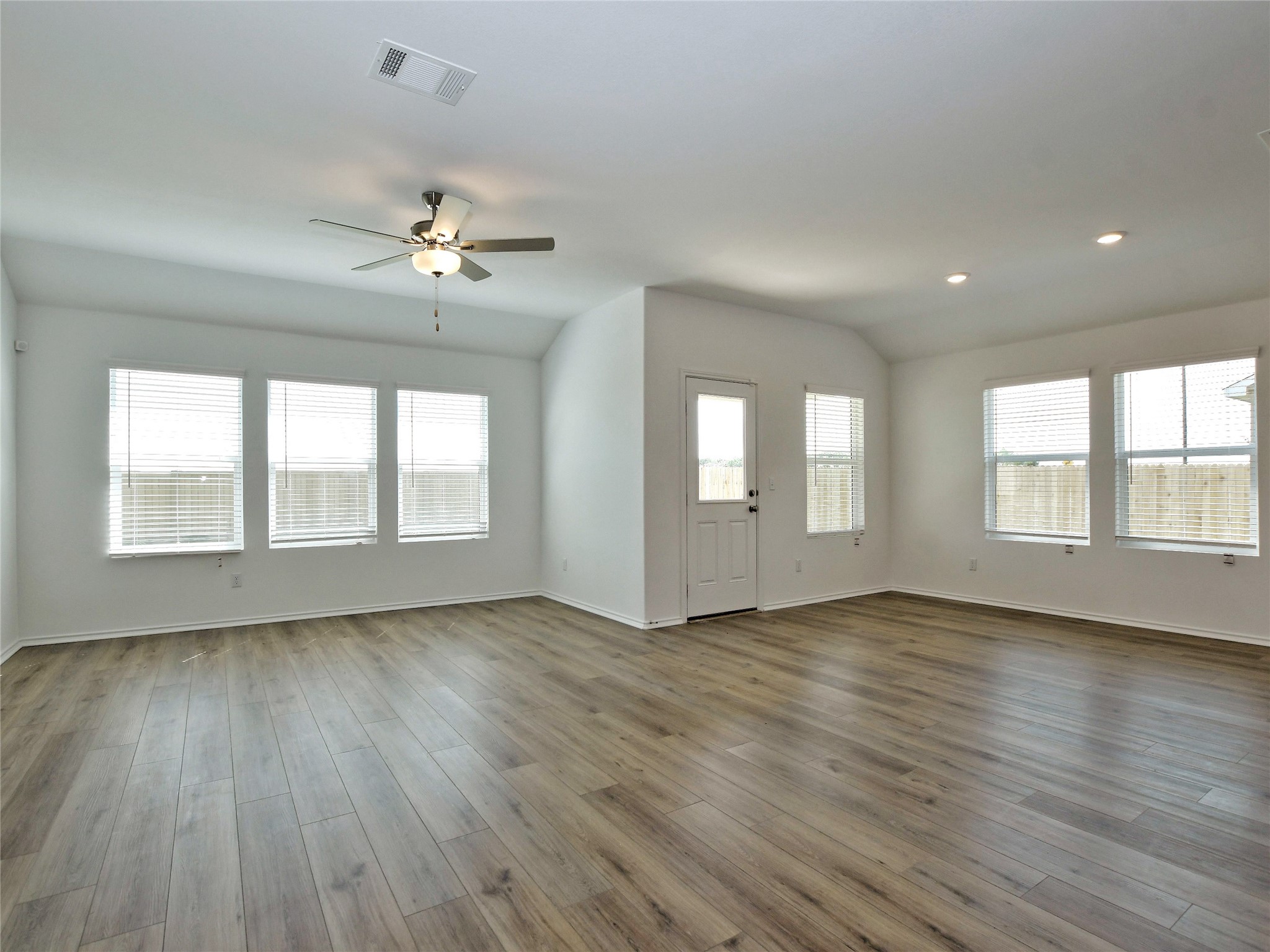 229 Vortex Pass Kyle, TX 78640 - Photo 6 of 32 a view of an empty room with a window and wooden floor