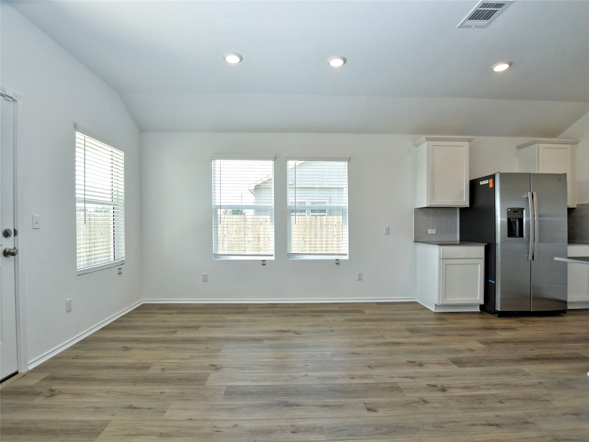 229 Vortex Pass Kyle, TX 78640 - Photo 8 of 32 an empty room with wooden floor and windows
