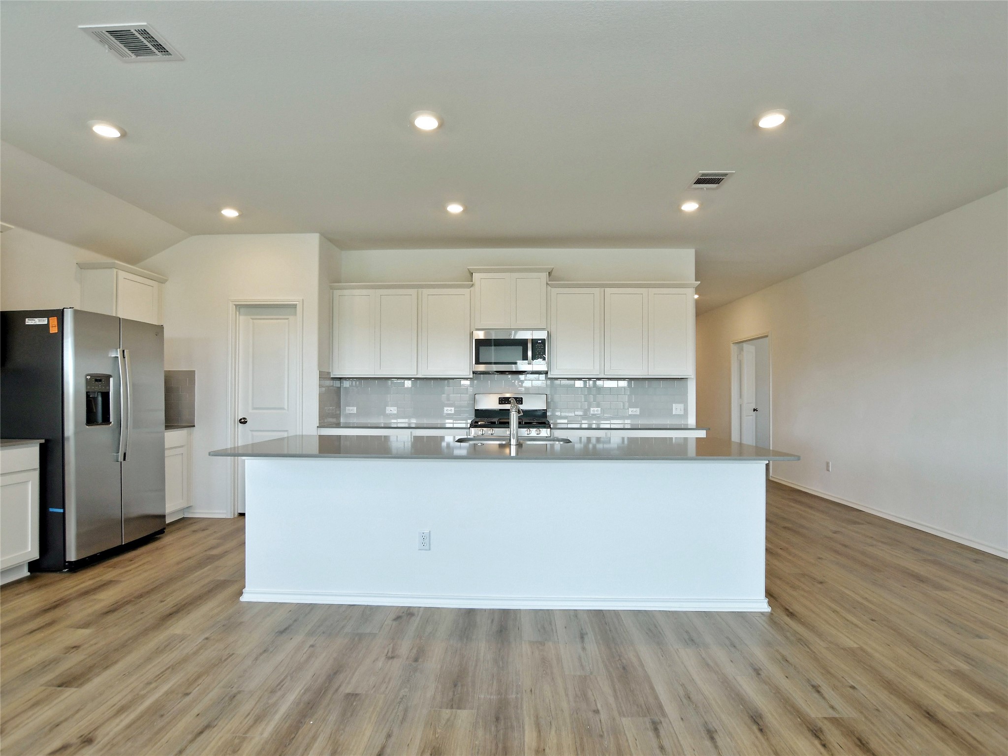 229 Vortex Pass Kyle, TX 78640 - Photo 9 of 32 a large kitchen with stainless steel appliances granite countertop a large counter top a sink and a stove