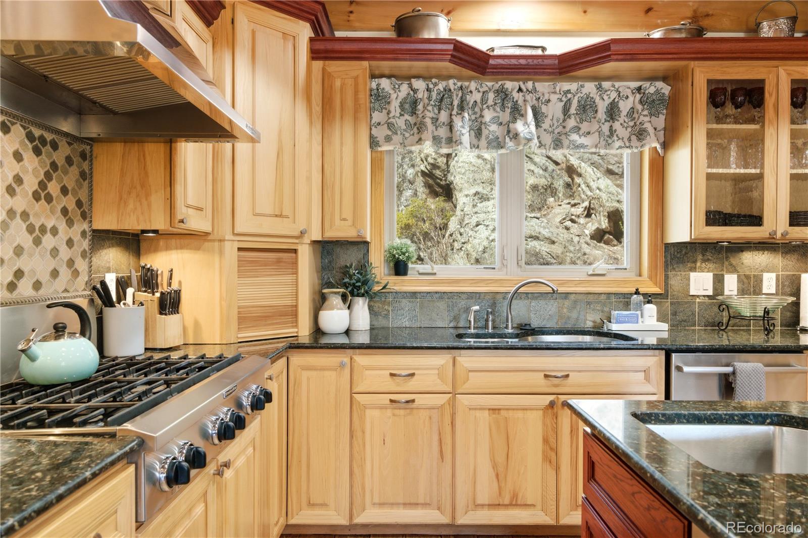 9659 South Turkey Creek Road Morrison, CO 80465 - Photo 11 of 49 a kitchen with granite countertop a stove a sink and a granite counter tops