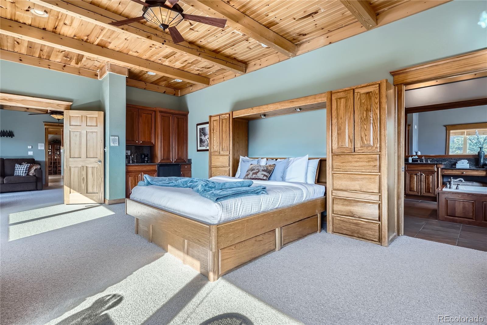 9659 South Turkey Creek Road Morrison, CO 80465 - Photo 17 of 48 a bedroom with a bed and a walk in closet