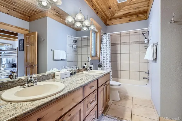 a bathroom with a sink a toilet a mirror and shower