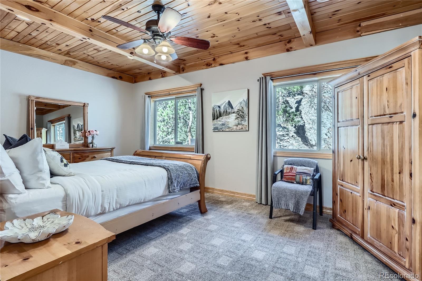 9659 South Turkey Creek Road Morrison, CO 80465 - Photo 23 of 48 a bedroom with a bed couch and a window