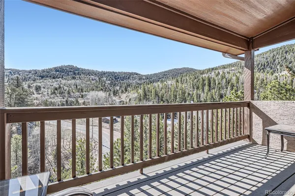 a balcony with wooden floor and city view