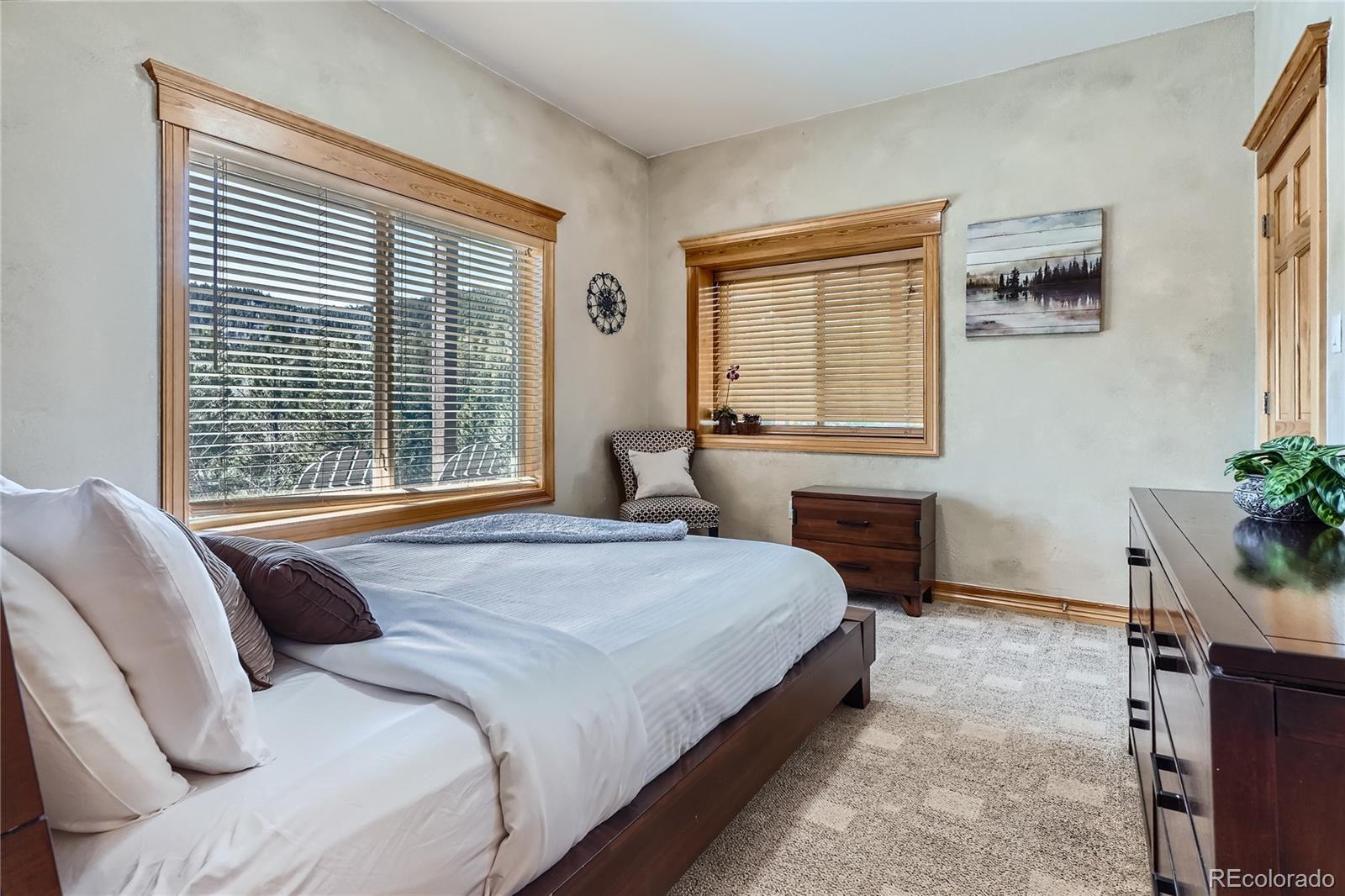 9659 South Turkey Creek Road Morrison, CO 80465 - Photo 30 of 48 a bedroom with a bed and glass window