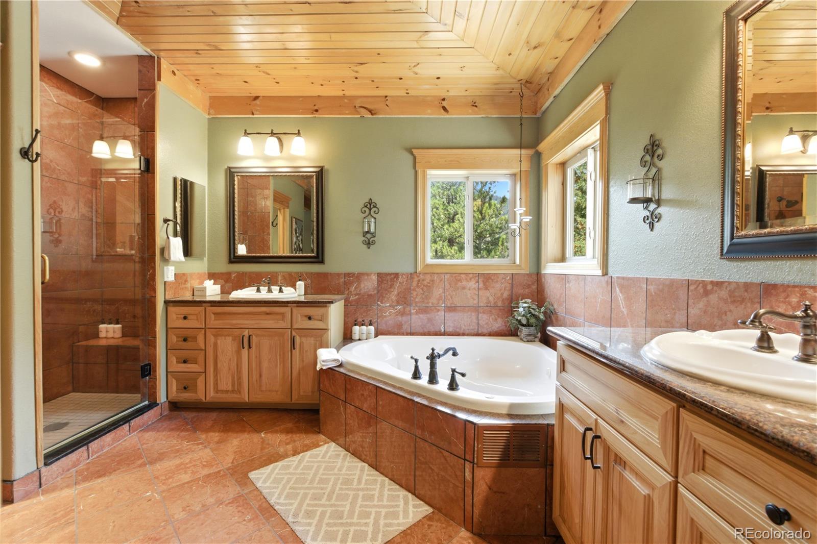 9659 South Turkey Creek Road Morrison, CO 80465 - Photo 30 of 49 a bathroom with a tub sink and mirror