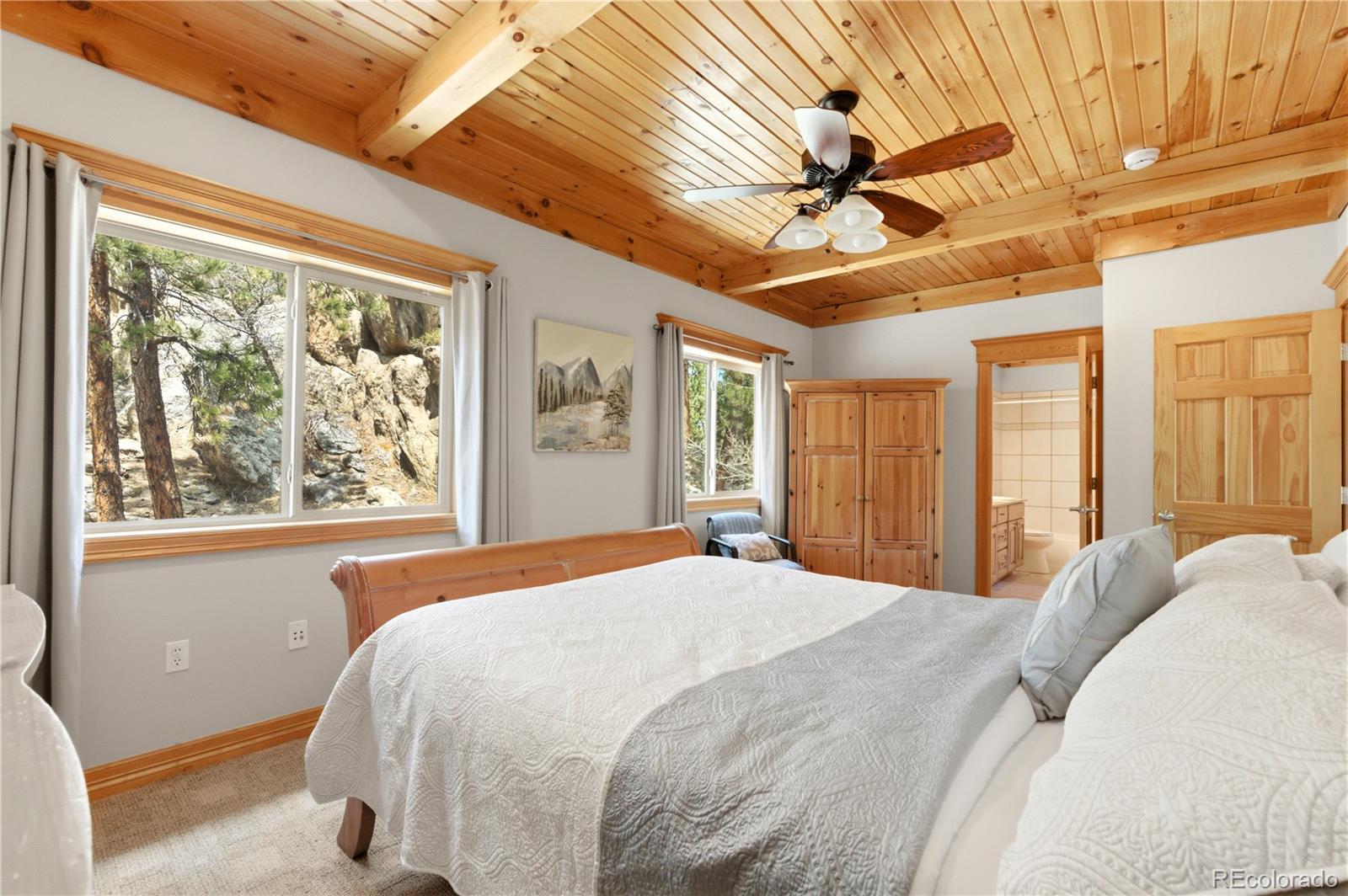 9659 South Turkey Creek Road Morrison, CO 80465 - Photo 32 of 49 a bedroom with a large bed and a large window with the outer view