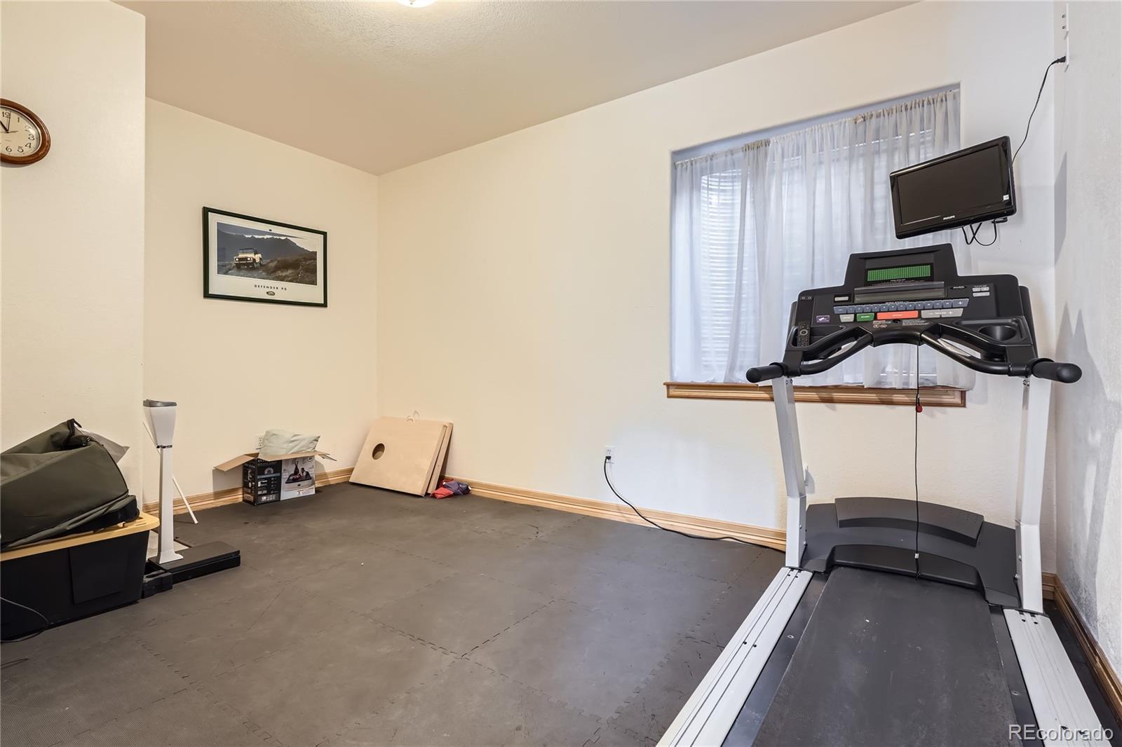 9659 South Turkey Creek Road Morrison, CO 80465 - Photo 34 of 48 a room with gym equipment and a flat screen tv