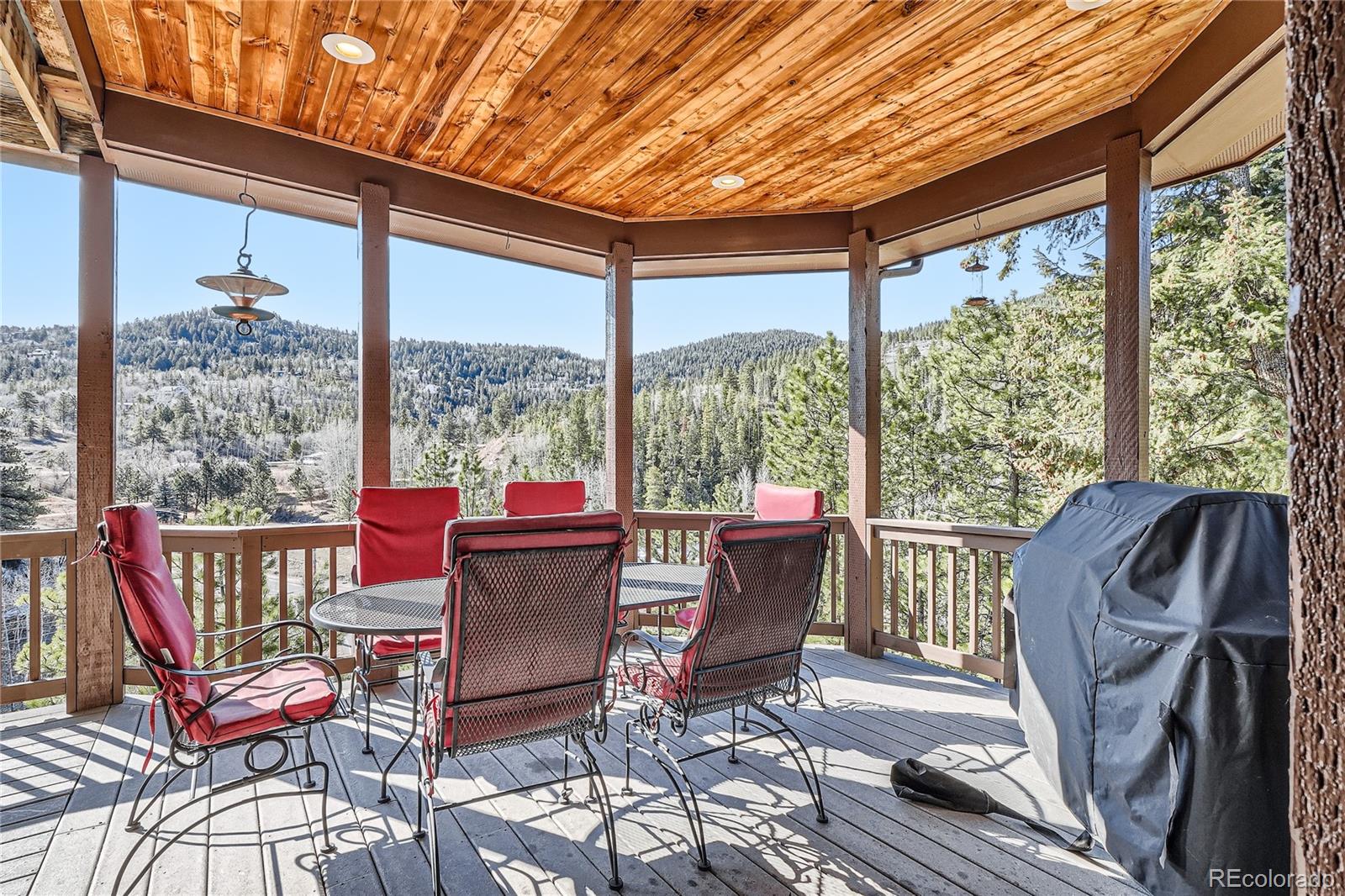 9659 South Turkey Creek Road Morrison, CO 80465 - Photo 4 of 48 a view of a patio with a dining table and chairs
