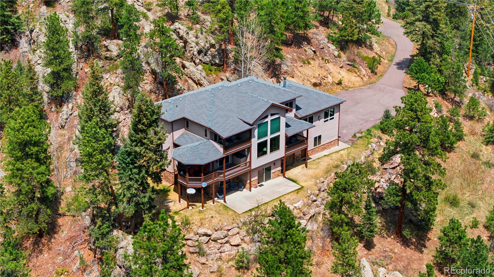 9659 South Turkey Creek Road Morrison, CO 80465 - Photo 49 of 49 an aerial view of a house with swimming pool and large trees