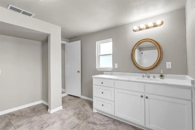 a bathroom with a granite countertop double vanity sink and a mirror