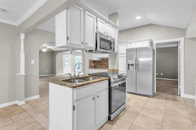 a kitchen with stainless steel appliances granite countertop a stove a microwave and a sink