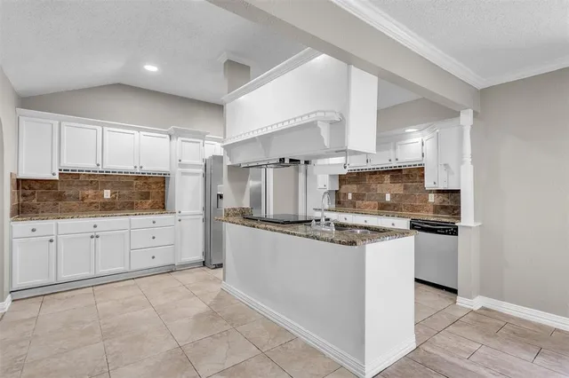 a kitchen with stainless steel appliances granite countertop a sink and a refrigerator
