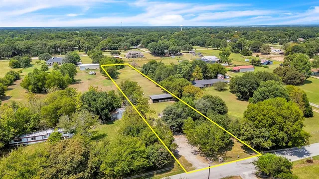 an aerial view of residential houses with outdoor space and trees