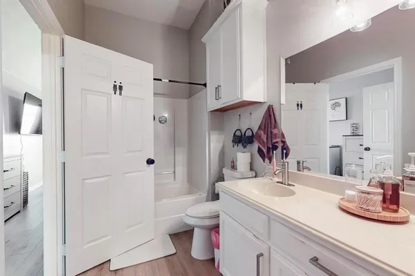 a bathroom with a sink vanity granite and toilet