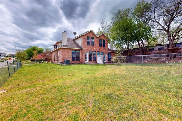 a view of a house with a big yard and large trees