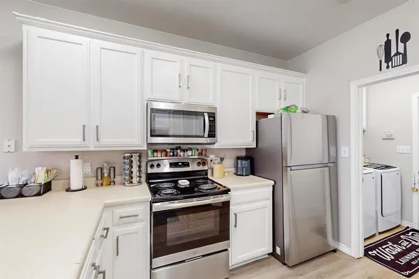 a kitchen with white cabinets and stainless steel appliances