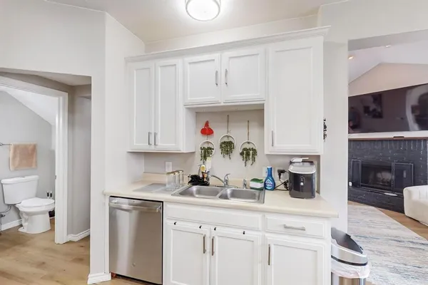 a kitchen with white cabinets and sink