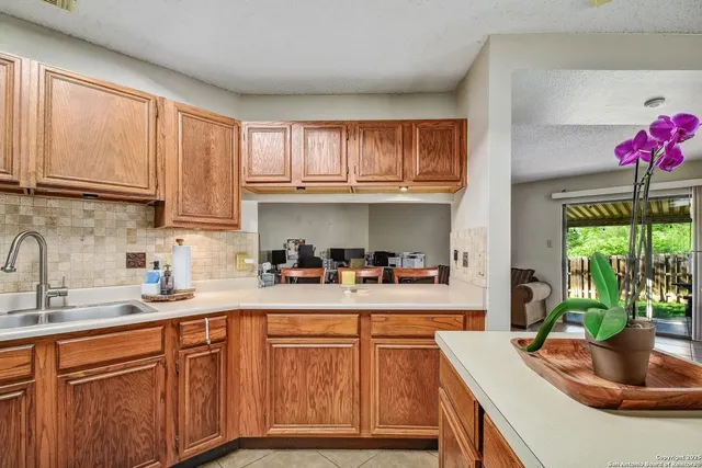 a kitchen with stainless steel appliances granite countertop a sink window and cabinets