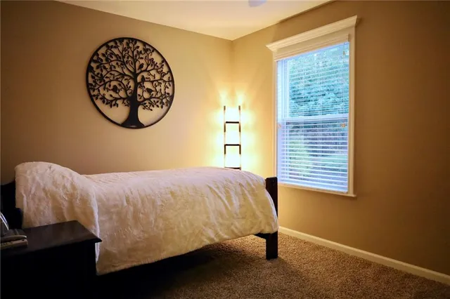 a bed sitting in a bedroom next to a window