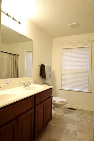 a bathroom with a double vanity sink toilet mirror and bathtub