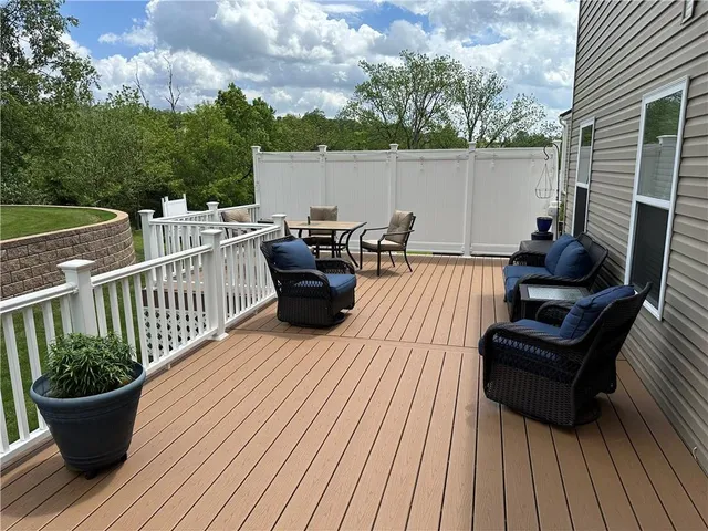 a view of a roof deck with table and chairs couches and wooden floor