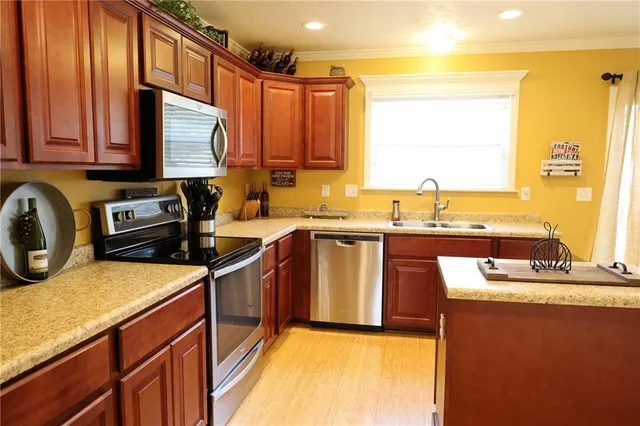 a kitchen with stainless steel appliances granite countertop a sink stove and refrigerator