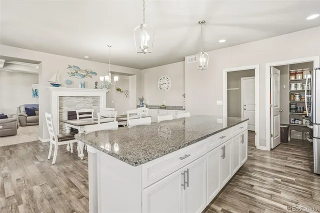 a large kitchen with kitchen island a large counter space a sink stainless steel appliances and cabinets