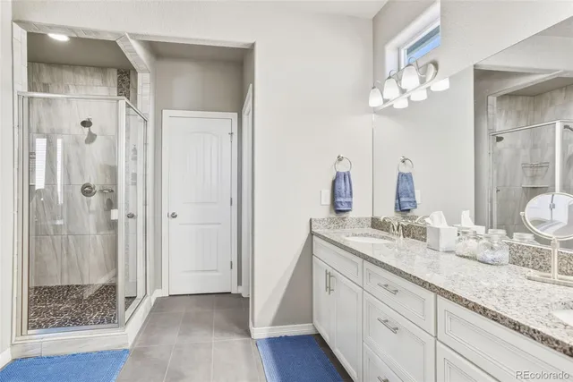 a spacious bathroom with a granite countertop sink a mirror and a shower