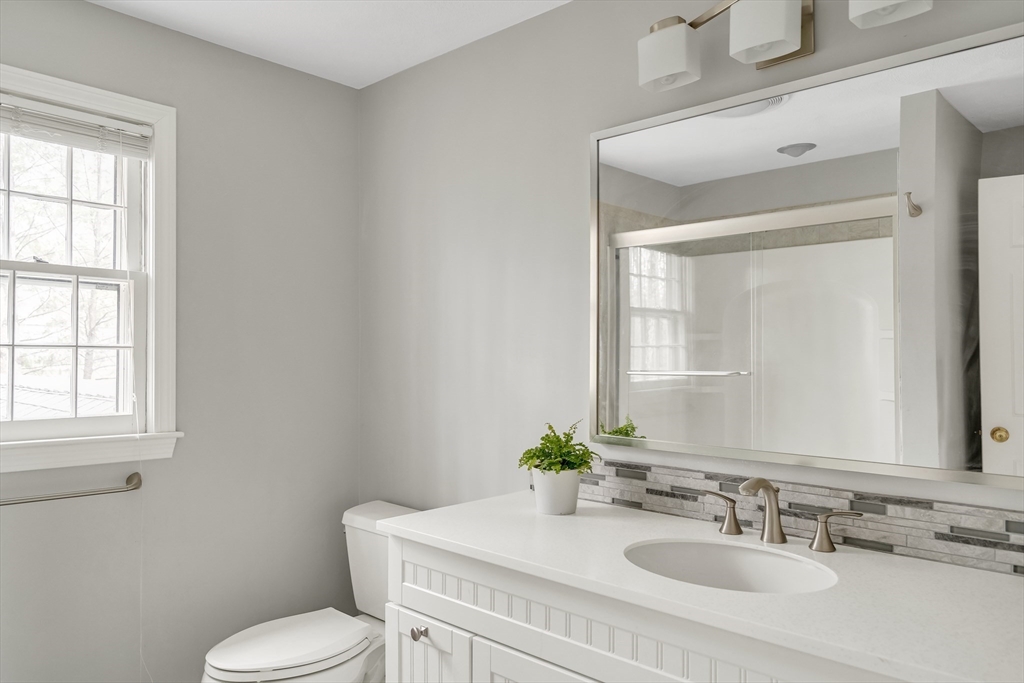 8 Highland Road Acton, MA 01720 - Photo 32 of 36 a bathroom with a granite countertop toilet sink and mirror
