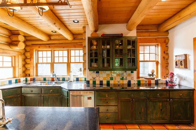 a kitchen with granite countertop a sink a counter space cabinets and stainless steel appliances