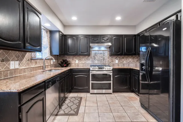 a kitchen with stainless steel appliances granite countertop a sink stove and refrigerator