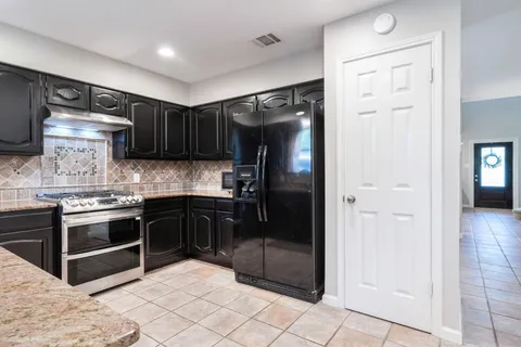a kitchen with stainless steel appliances granite countertop a refrigerator and a sink