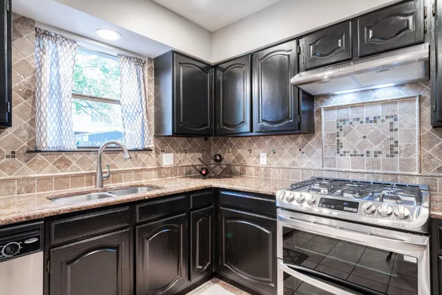 a kitchen with stainless steel appliances a stove a sink and a microwave
