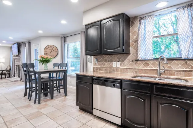 a kitchen with granite countertop a sink and a refrigerator