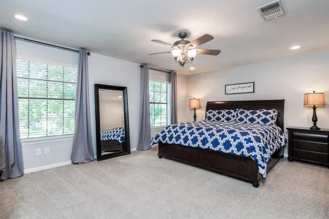 a bedroom with a large bed and a chandelier