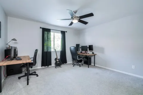 a view of a workspace with furniture and a window