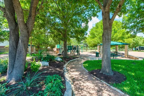 a view of yard with green space and trees