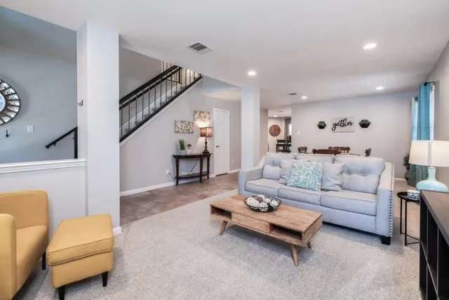 a living room with furniture and a ceiling fan